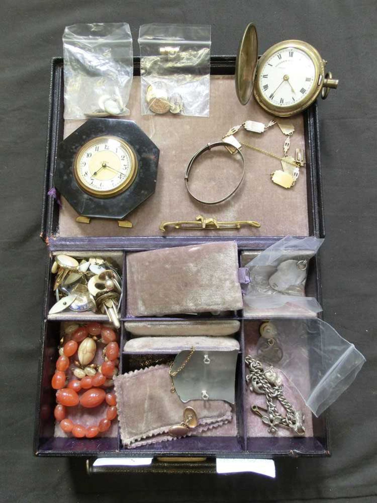 A leather bound jewellery box containing an assortment of yellow metal cuff links, a bracelet marked