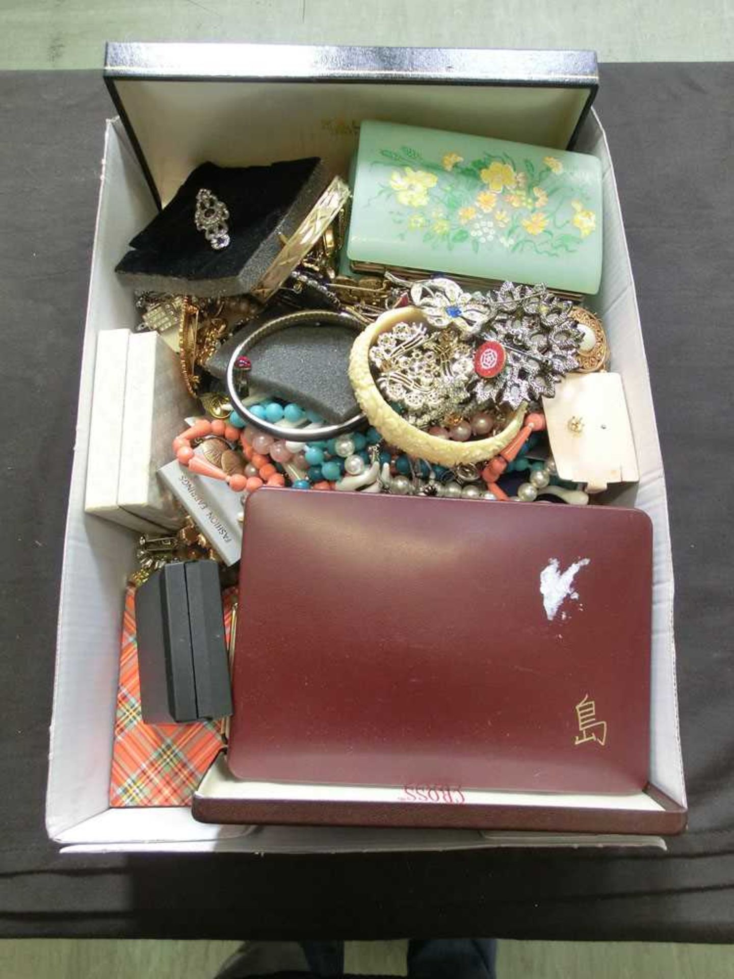 A box containing a large quantity of costume jewellery to include beads, brooches, bracelets, etc