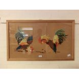 A framed and glazed needlework depicting cockerels fighting