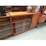 A mid-20th century teak glazed bookcase with cupboard door