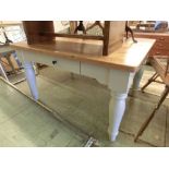 An oak topped kitchen table with cream base and single side drawer