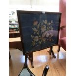 A mid-20th century mahogany framed firescreen having a glazed woolwork panel