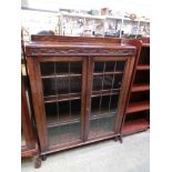 An early 20th century oak leaded glazed two door bookcase