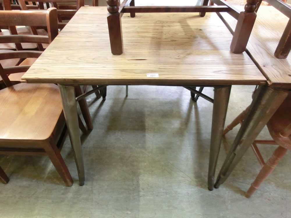 An industrial metal framed table with wooden top