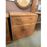 A mid-20th century oak veneered cabinet having two drawers above a pair of cupboard doors by G-plan