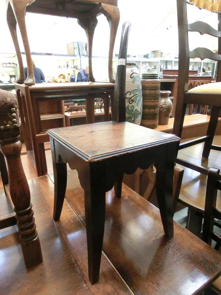 An early 20th century oak corner chair with one spindle back