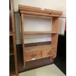 A set of waxed pine wall shelves having open storage above two drawers