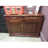 A modern mahogany effect cabinet having two drawers above a pair of doors