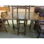 An early 20th century oak drop leaf table on barley twist supports