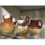 Three brown glazed jugs and a similar mug, by Royal Doulton and Doulton Lambeth