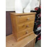 A modern pine three drawer bedside chest