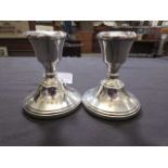 A pair of silver hallmarked weighed squat candle sticks