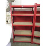 A red metal framed set of shelves