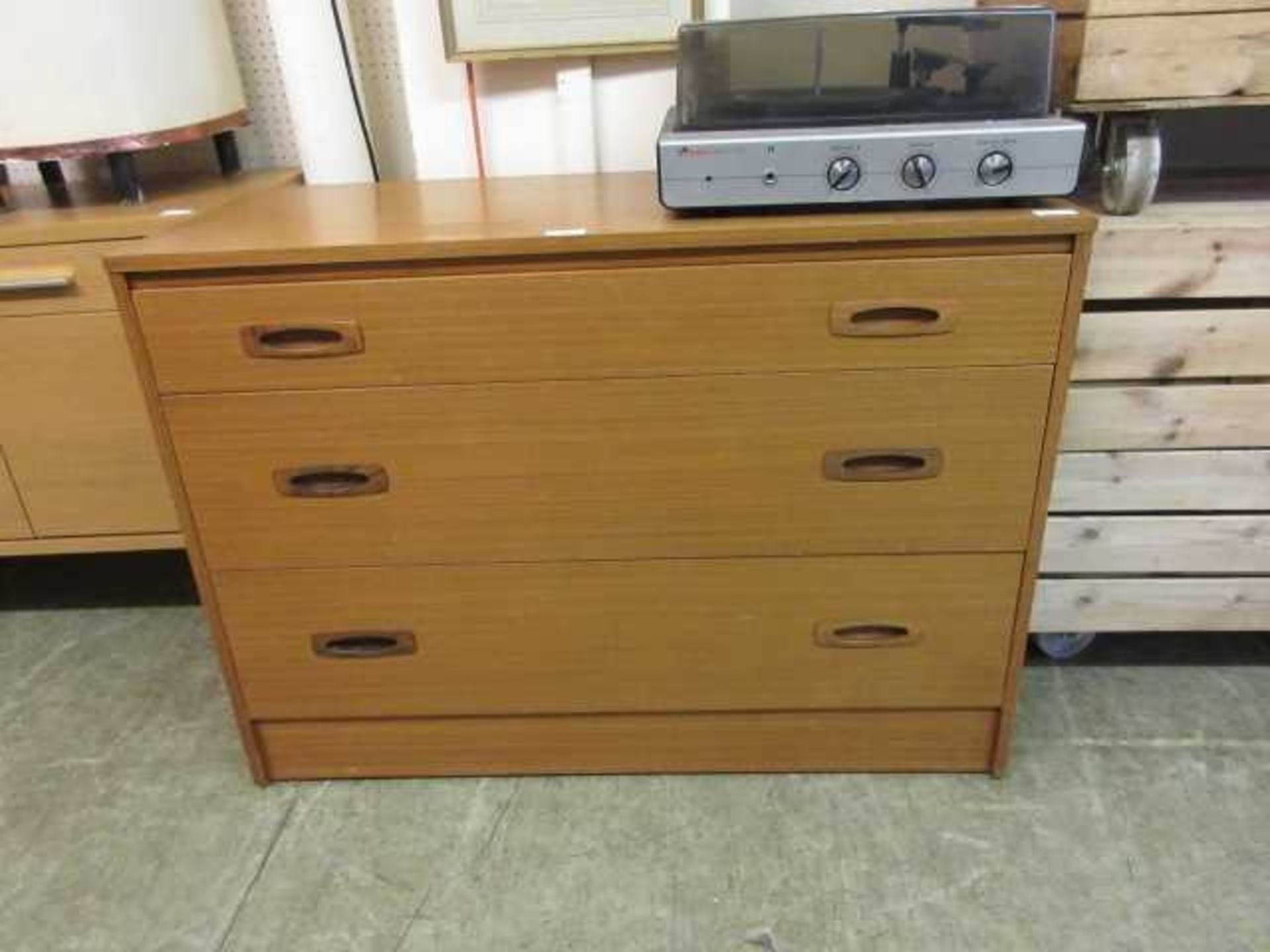 A mid-20th century teak veneered chest of three long drawers