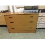 A mid-20th century teak veneered chest of three long drawers