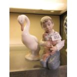 Two Nao ceramic figurines, one of goose, the other of a boy with a dog