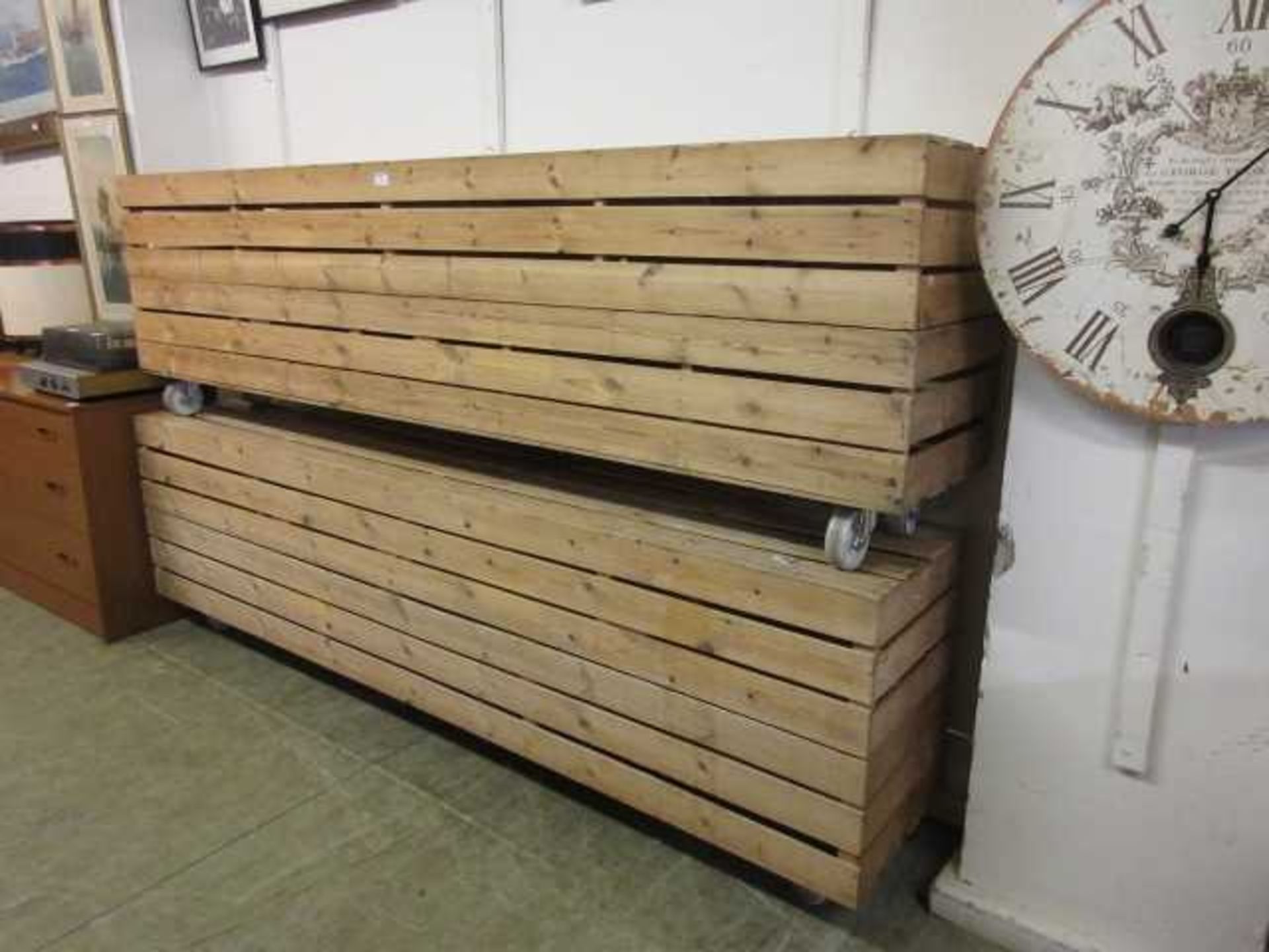 Two slatted pine garden benches on casters