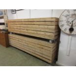 Two slatted pine garden benches on casters