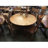 A modern oak single pedestal dining table with a set of four similar high back chairs