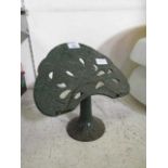 A green cast metal book stand with bird design