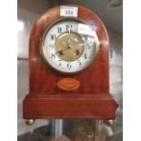 A mahogany cased mantle clock with brass bun feet