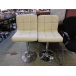 A pair of modern cream upholstered stools on chrome bases