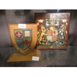 Two wooden coats of arms, one on shield plaque