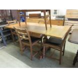 An early 20th century oak drawer leaf dining table with a set of four oak framed chairs