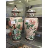 A pair of oriental style lidded vases with bird on branch design and foo dog handles to lidsDamage