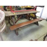 A weathered wooden pub style garden table with benches to each side