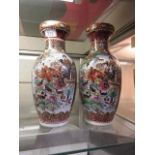 Two oriental style red ground vases depicting boating scene