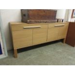 A modern oak effect sideboard, two drawers over four cupboard doors