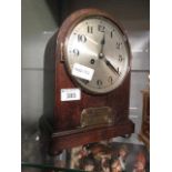 An oak cased mantle clock with brass presentation plaque to base