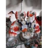 A pair of Staffordshire style hearth dogs along with a Staffordshire flatback of man and woman