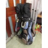 two golf bags containing a selection of golf clubs together with two golf trolleys