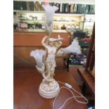 A continental moulded three light table lamp in the form of lady with bird