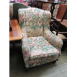 An early 20th century wing armchair upholstered in a floral fabric