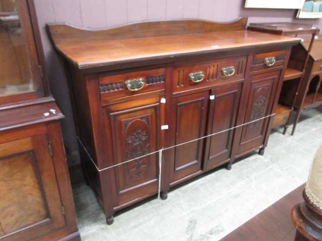 An early 20th century walnut sideboard, the top over three drawers and four cupboard doors, two of