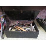 A large black painted toolbox with a large quantity of hand tools to include hammers, spanners, etc