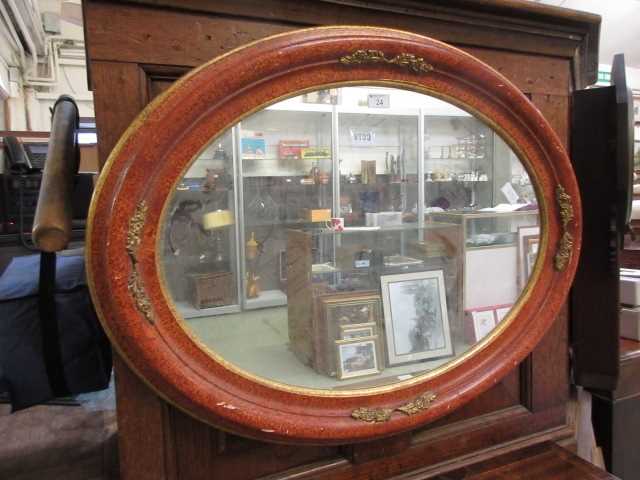 An ornate parcel gilt oval framed mirror