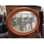 An ornate parcel gilt oval framed mirror
