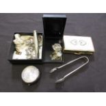 A box containing an assortment of items to include white metal charm bracelet, tongs, ashtray, etc