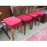 A set of four mid-20th century stools having red cut fabric seat
