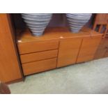 A mid-20th century wooden cabinet having three drawers and a pair of cupboard doors