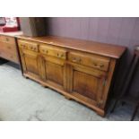A high quality reproduction oak dresser base having three drawers above cupboard doors