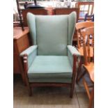 An oak framed wing armchair upholstered in a turquoise draylon fabric