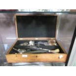 A wooden case containing a quantity of flatware, some with bone handles