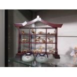 A wooden oriental style stand with a selection of Chinese style gilt metal miniature animal signs of