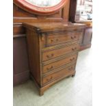 A reproduction mahogany and banded bachelor's chest, the fold over top over four long drawers