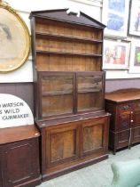 An early 20th century walnut bookcase, the pediment over open storage, glazed doors, and two blind
